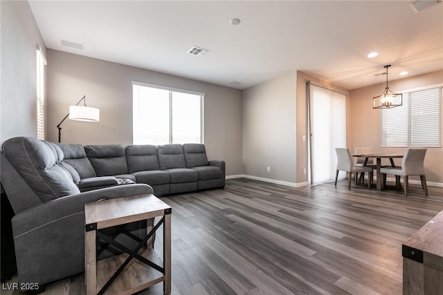 living room with an inviting chandelier and dark hardwood / wood-style flooring