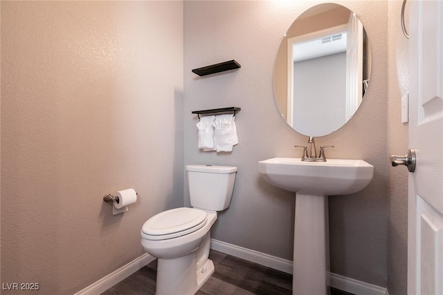 bathroom featuring sink, wood-type flooring, and toilet