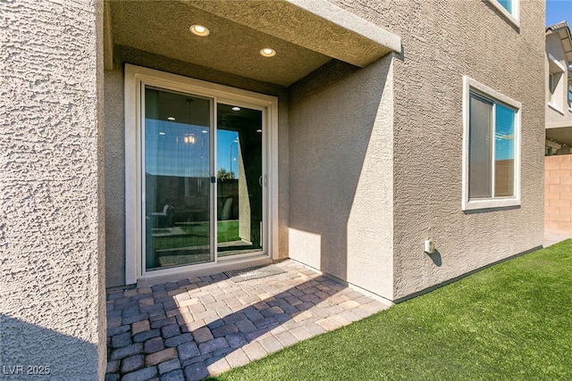 view of exterior entry featuring a patio area