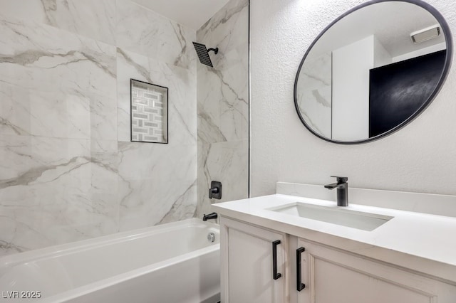 bathroom featuring tiled shower / bath and vanity