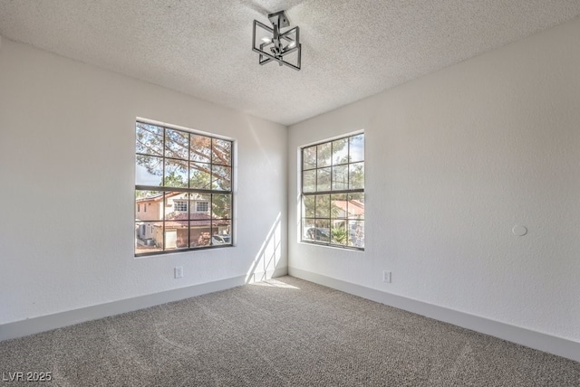 empty room featuring carpet, a textured ceiling, and a healthy amount of sunlight