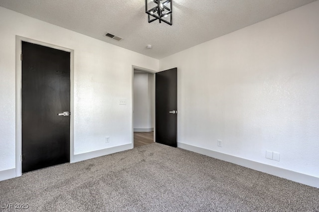 unfurnished bedroom with carpet floors and a textured ceiling