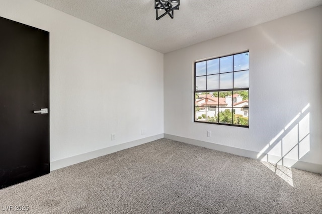 carpeted spare room featuring a textured ceiling