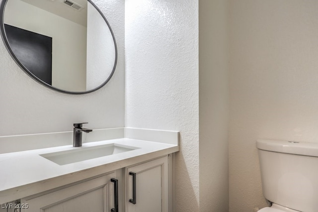 bathroom featuring toilet and vanity