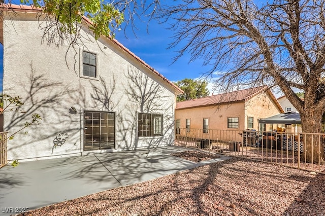 rear view of property featuring a patio area and a gazebo