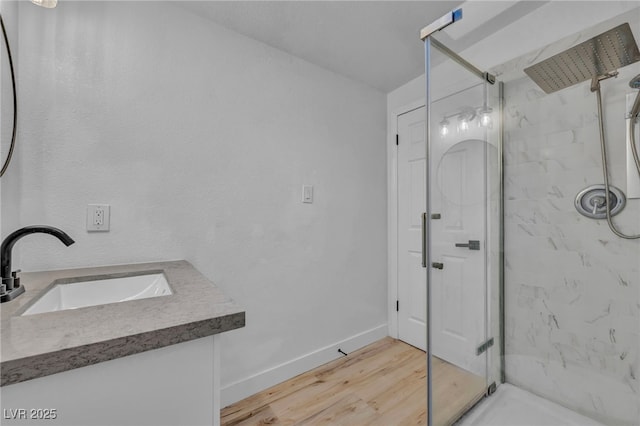 bathroom with a shower with shower door, sink, and hardwood / wood-style floors