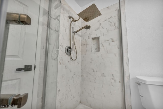 bathroom with toilet and a tile shower