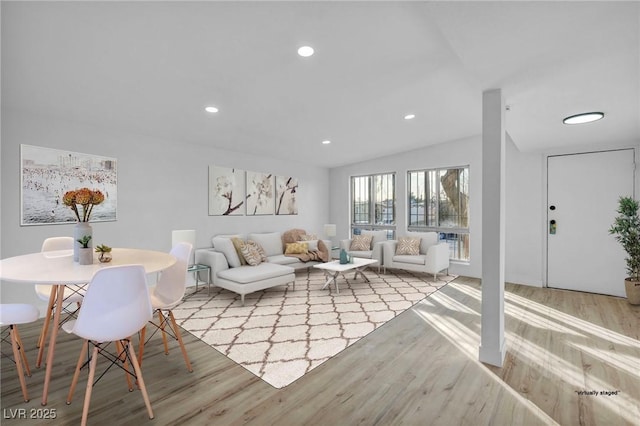 living room with light hardwood / wood-style flooring and vaulted ceiling