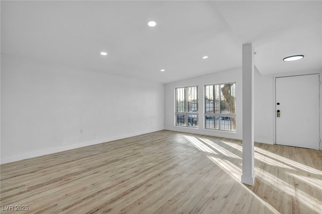 unfurnished living room with vaulted ceiling and light hardwood / wood-style flooring