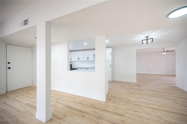 basement with light wood-type flooring and ceiling fan