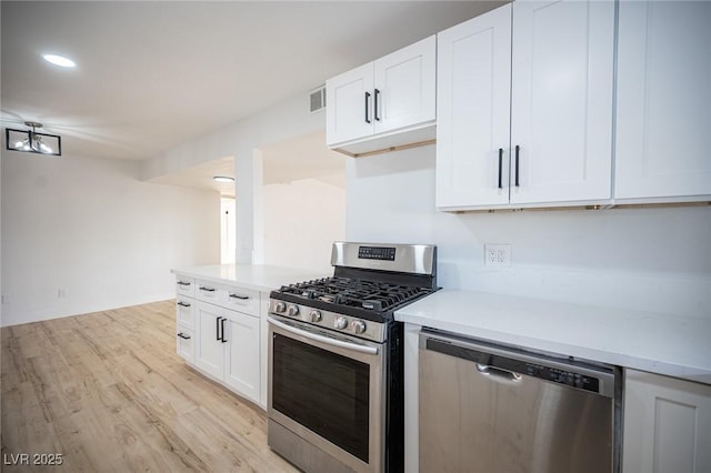 kitchen featuring appliances with stainless steel finishes, white cabinetry, and light hardwood / wood-style floors