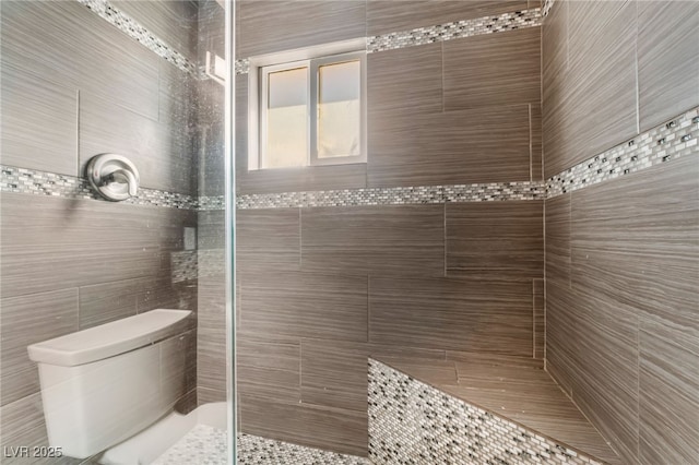 bathroom with toilet and a tile shower