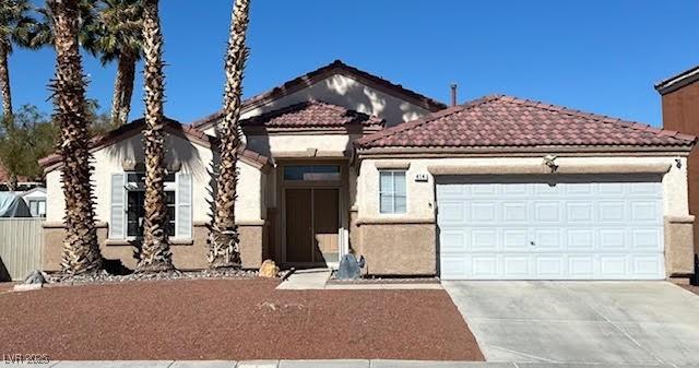 view of front of home featuring a garage, concrete driveway, stucco siding, and a tile roof