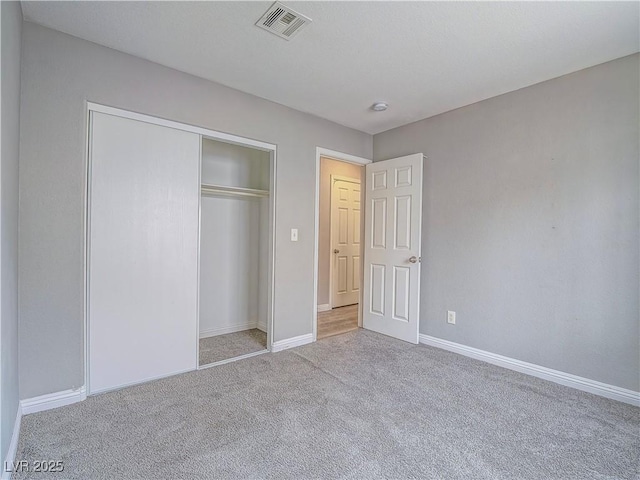 unfurnished bedroom featuring a closet, baseboards, visible vents, and carpet floors