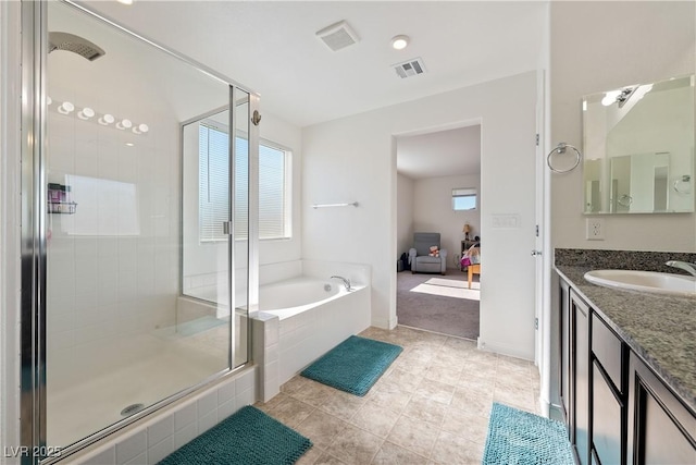 bathroom featuring vanity and independent shower and bath