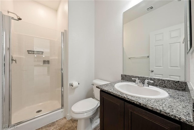 bathroom featuring toilet, tile patterned flooring, walk in shower, and vanity