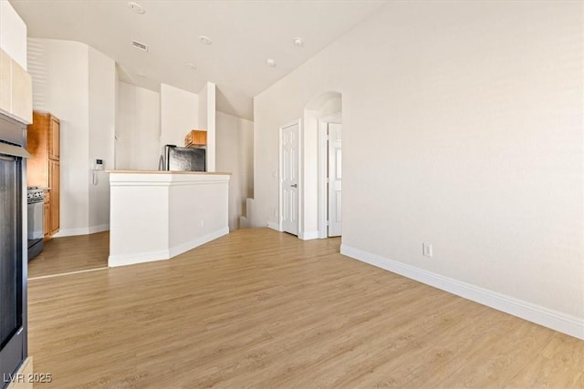 unfurnished living room with light hardwood / wood-style floors and vaulted ceiling