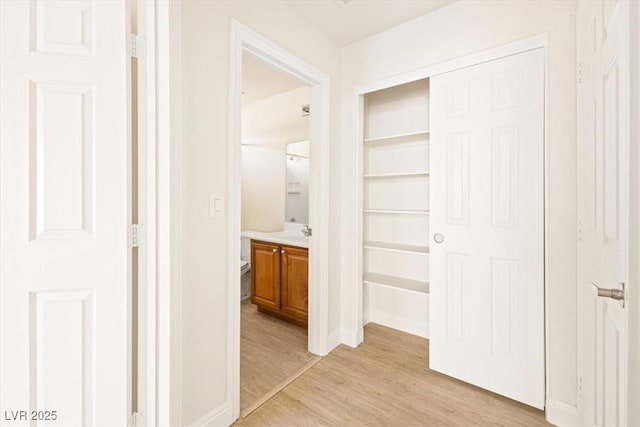 hall featuring sink and light wood-type flooring