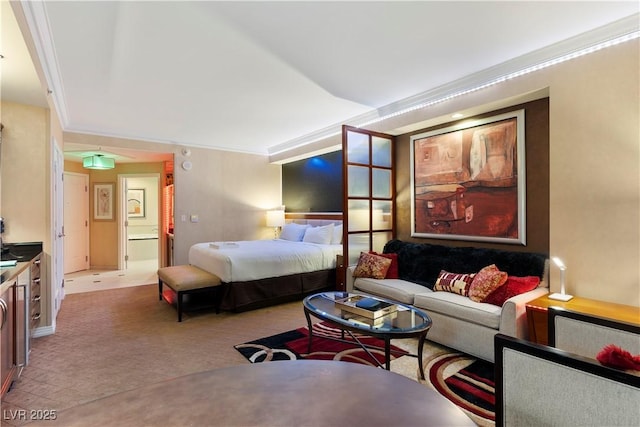 bedroom featuring crown molding, light colored carpet, and ensuite bath