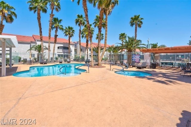 view of swimming pool featuring a patio area and a hot tub