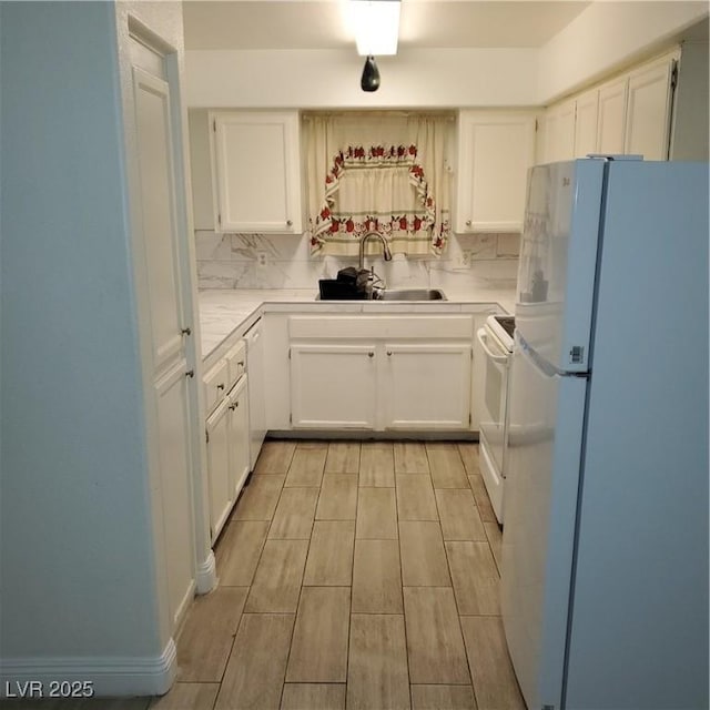 kitchen featuring decorative backsplash, sink, white appliances, and white cabinetry