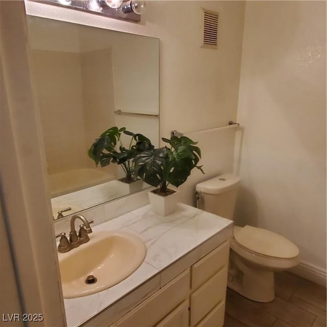 bathroom with toilet, tile patterned floors, and vanity