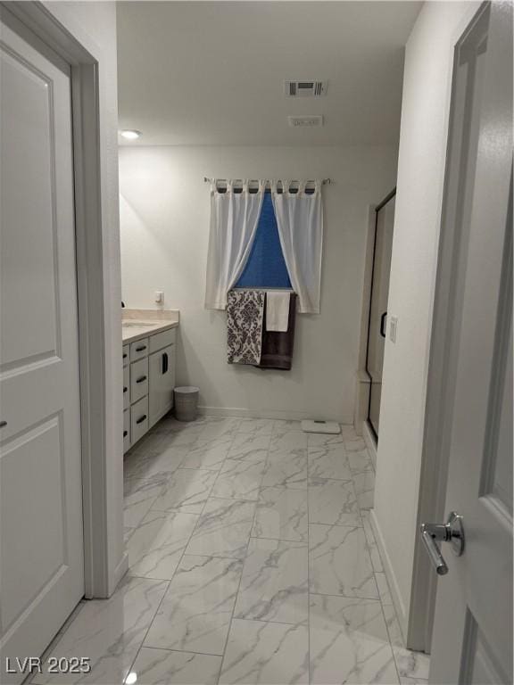 bathroom featuring walk in shower and vanity