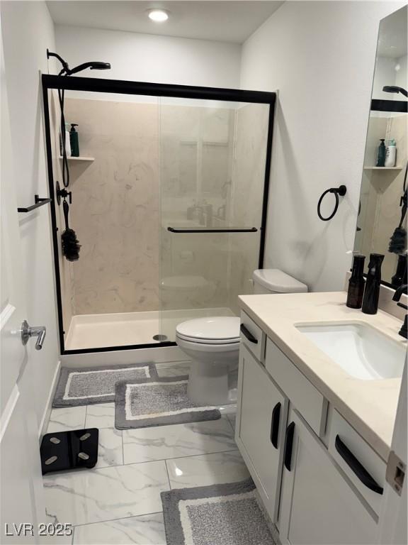 bathroom with toilet, a shower with door, and vanity