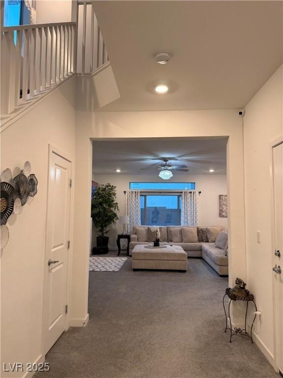 living room featuring ceiling fan and dark carpet