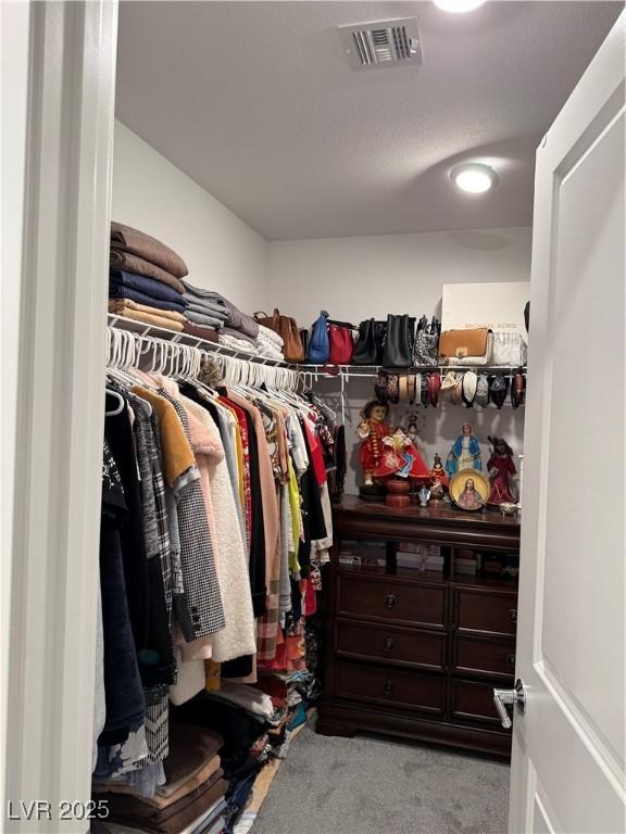 walk in closet featuring light colored carpet