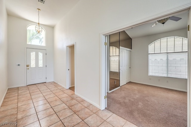 foyer entrance featuring light tile patterned flooring and a high ceiling