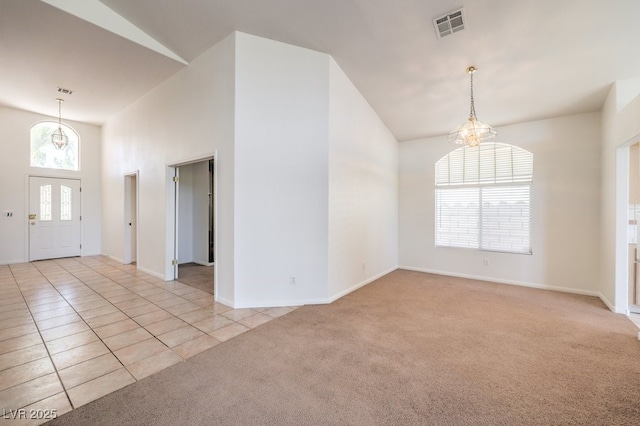 interior space featuring light carpet, a chandelier, and vaulted ceiling