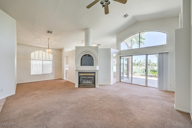 unfurnished living room with ceiling fan, light colored carpet, and vaulted ceiling