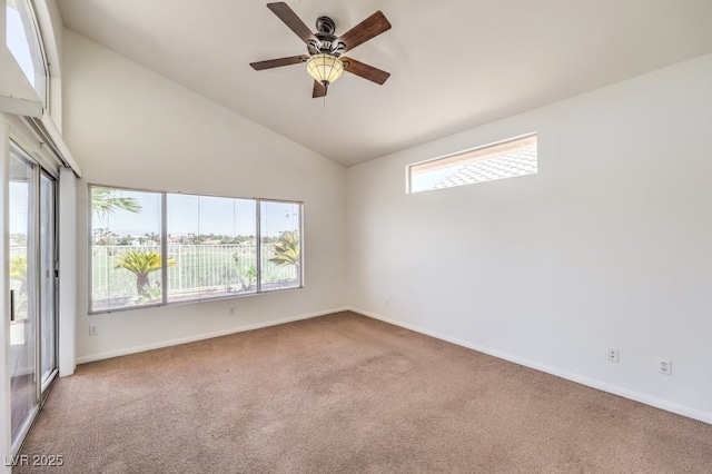 empty room featuring lofted ceiling, ceiling fan, carpet, and a wealth of natural light