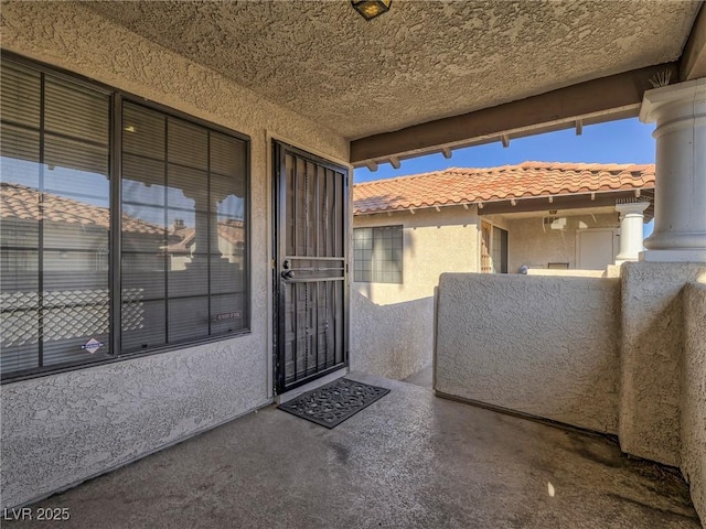 view of exterior entry with a balcony