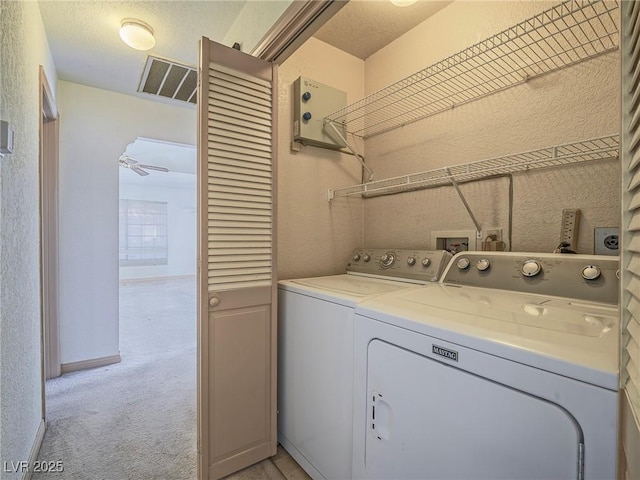 laundry area with light colored carpet, independent washer and dryer, and ceiling fan