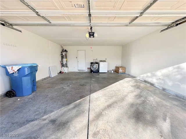 garage featuring water heater, a garage door opener, and washer and dryer