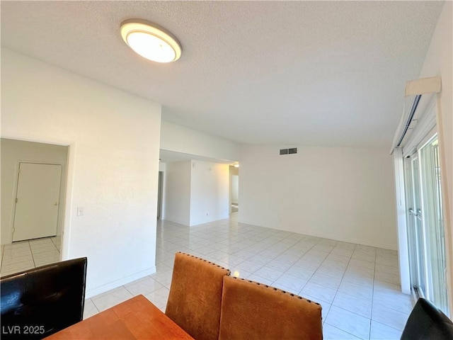 interior space with a textured ceiling and vaulted ceiling