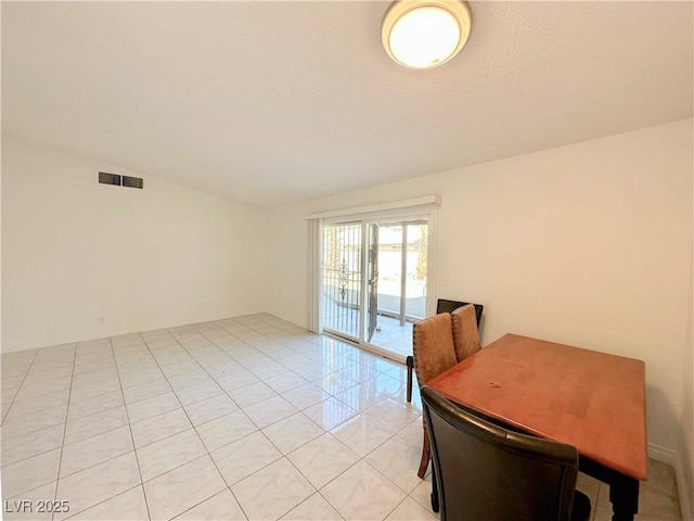 dining space featuring vaulted ceiling and light tile patterned floors