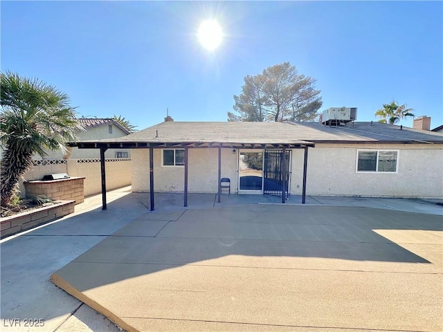 back of property with central AC and a patio