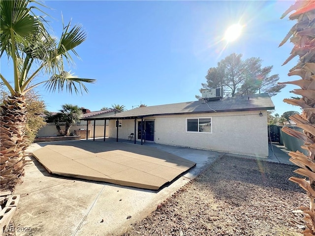 back of property with central AC unit and a patio