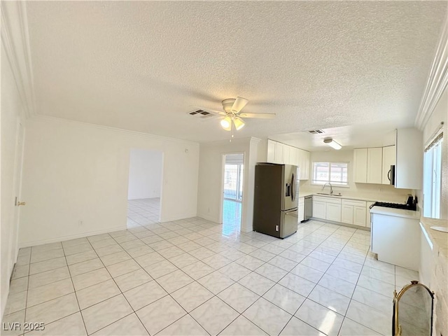 kitchen with appliances with stainless steel finishes, white cabinetry, sink, ceiling fan, and light tile patterned floors