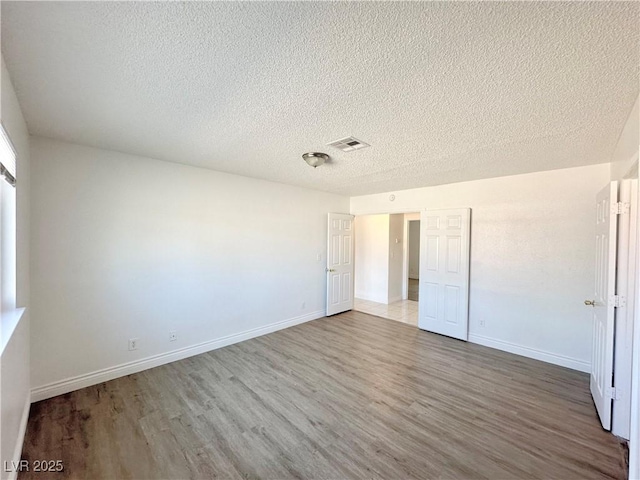 unfurnished bedroom with hardwood / wood-style flooring and a textured ceiling