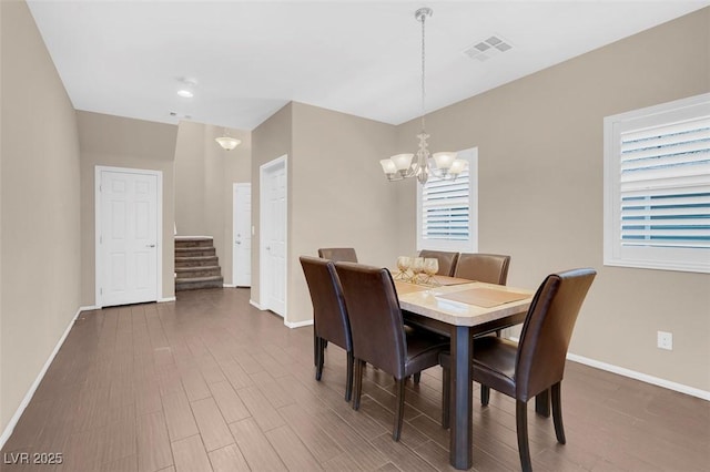 dining room with an inviting chandelier, a wealth of natural light, and dark hardwood / wood-style floors