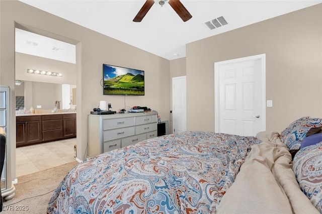 bedroom with ceiling fan, lofted ceiling, and ensuite bath