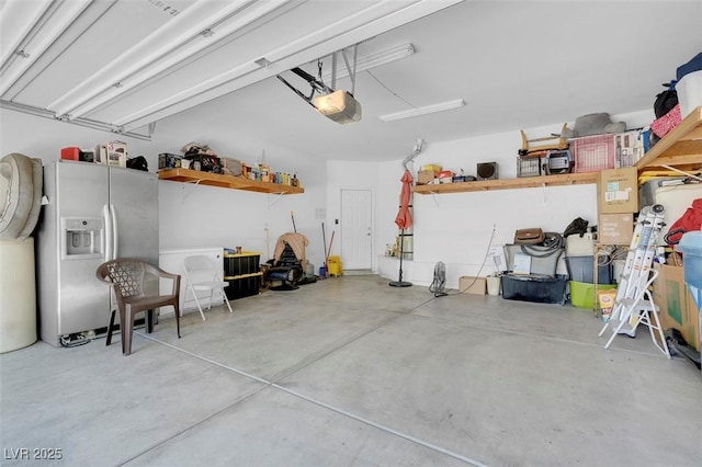 garage featuring stainless steel fridge and a garage door opener