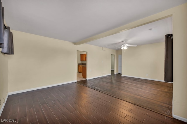 spare room featuring ceiling fan, dark hardwood / wood-style floors, and beam ceiling