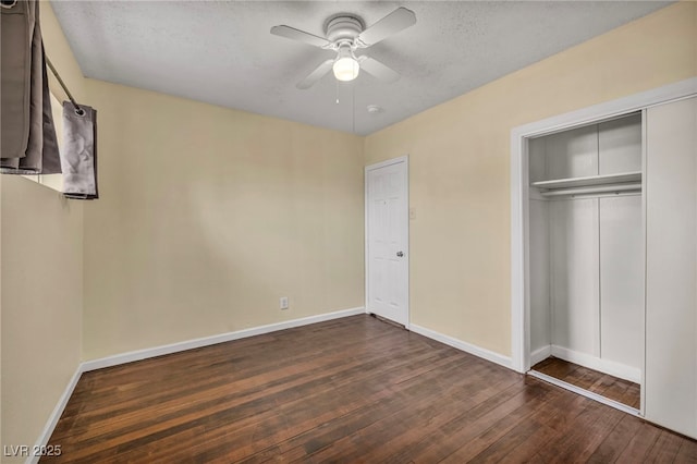 unfurnished bedroom with ceiling fan, a closet, dark hardwood / wood-style flooring, and a textured ceiling