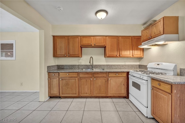 kitchen featuring light tile patterned floors, sink, and white range with gas stovetop