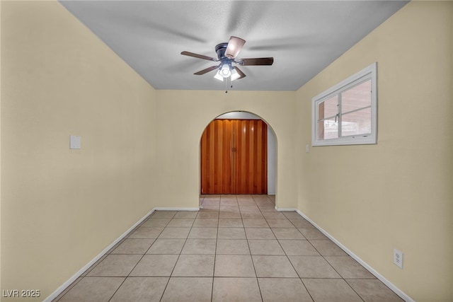 tiled spare room featuring ceiling fan